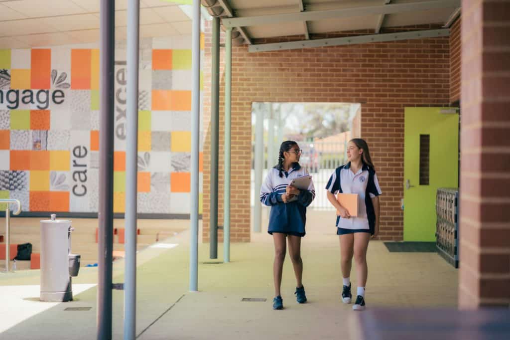 Two Duncraig Senior High students walk down a school hall